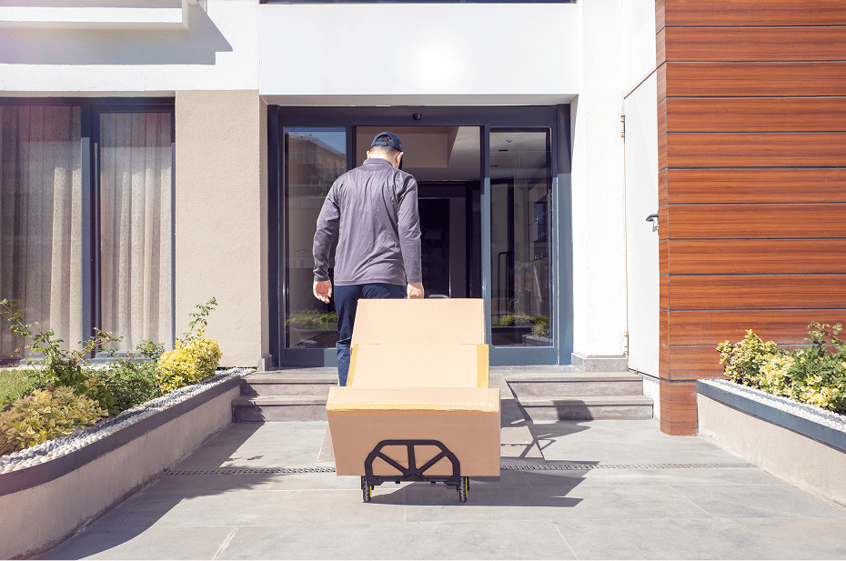 Person moving boxes on a dolly outside.