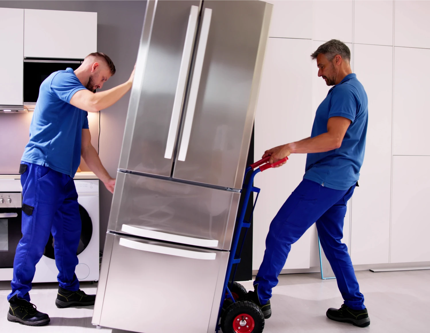 Movers transporting a refrigerator with a dolly.