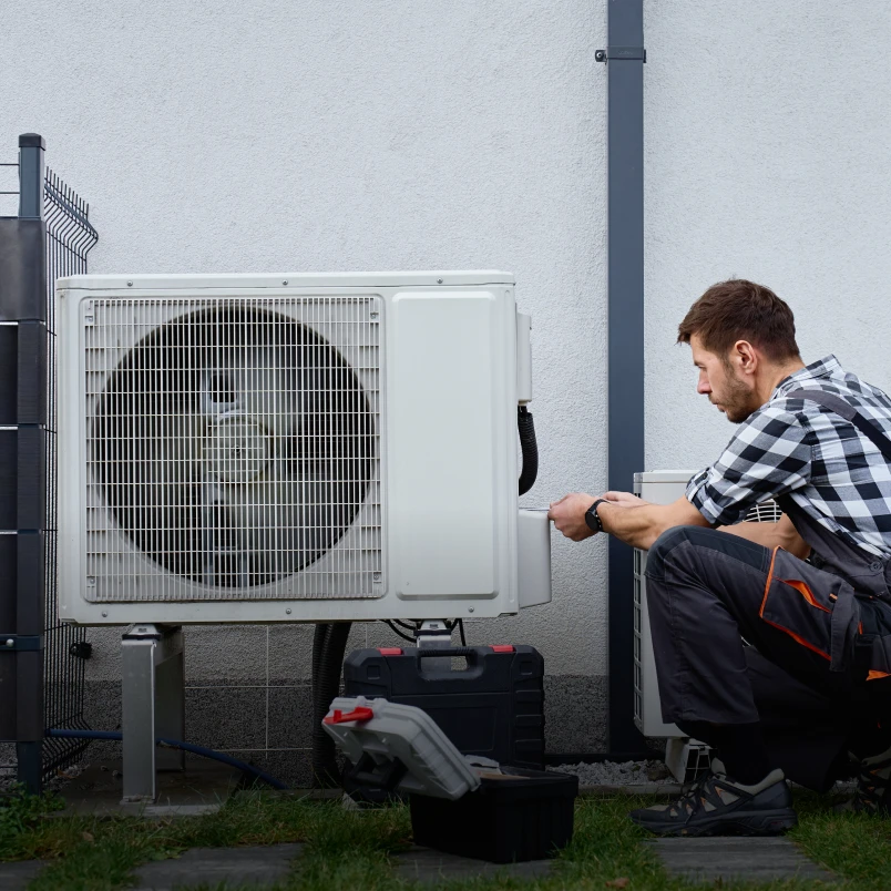 Technician repairing outdoor air conditioning unit.